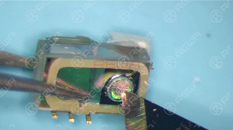 The chip on the left is used to store data, whereas the chip on the right side acts just like a projector. We can see that there are thousands of dots arranged here. The infrared light is emitted from here. Since necessary power supply is needed for chip on the right side to work normally, once water damaged, circuits here are most likely to get short. Which can also result in Face ID not working. And please be noted that the chip is exposed without black adhesive seal. So it can be easily damaged once water-damaged or dropped. What’s more, it also can not be restored once damaged. And this is the internal structure of the dot projector. Let’s continue with the crystal part of the dot projector.