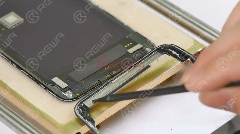 Tips: when detaching the bezel at the bottom area of the phone, we need to insert the metal pry piece under the bracket covering the bottom flex cable bonding area and slide back and forth. This is to confirm that the cold adhesive here has been sliced open. The bezel has been removed completely. As you can see, the area here is adhered by cold adhesive in large amounts. To protect the OLED from damage, we'd better freeze the screen during the operation. 