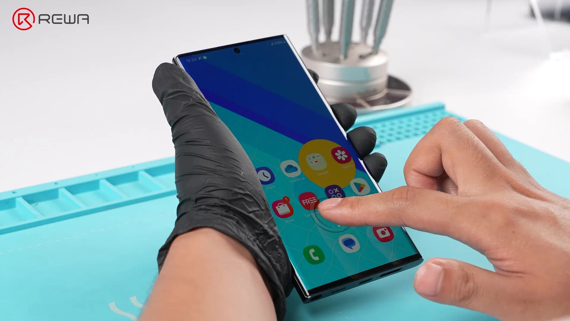 A finger activates the under-display fingerprint sensor on a Samsung smartphone with an aftermarket OLED screen