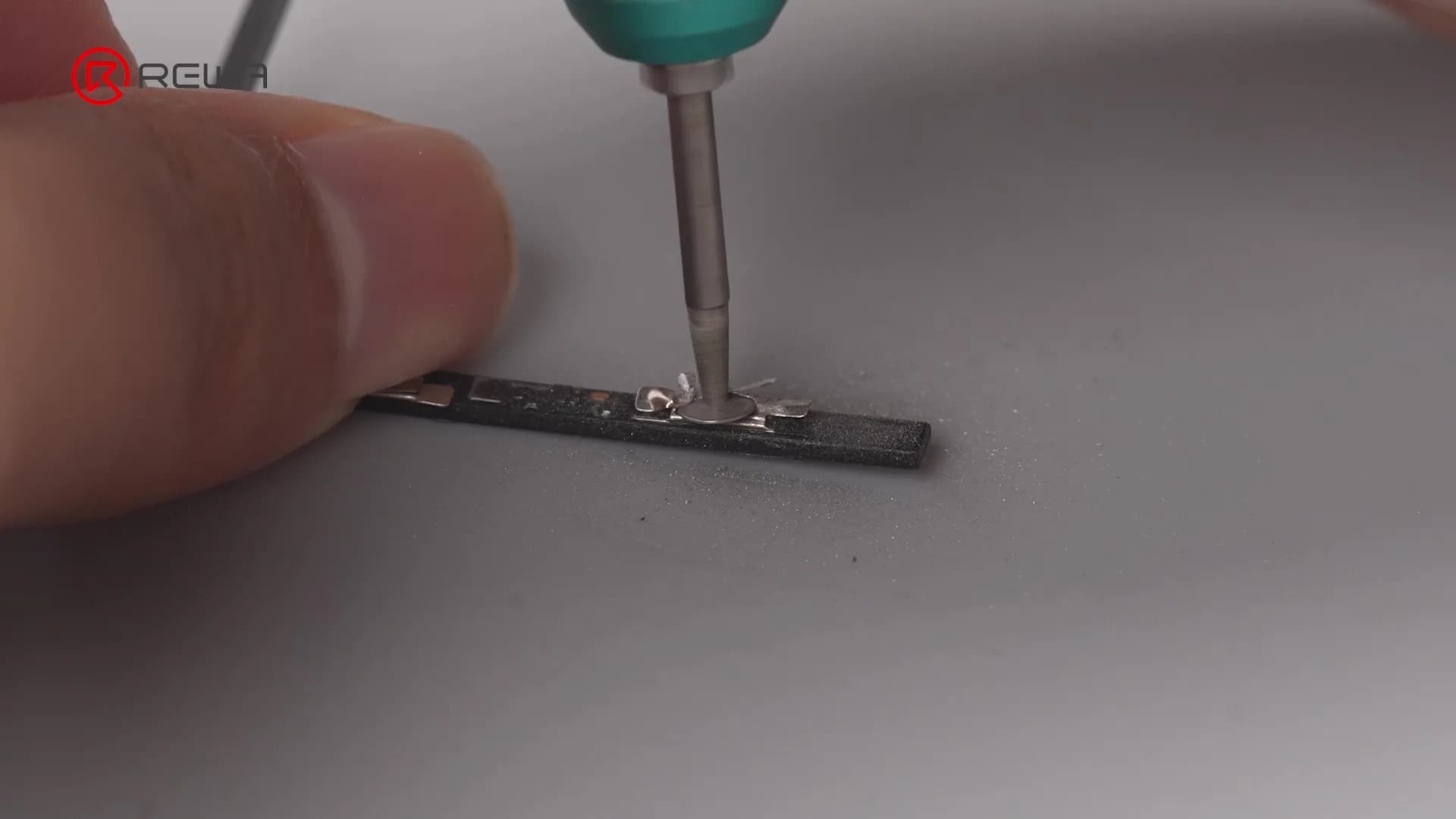 Un técnico utilizando una herramienta de precisión en un componente electrónico pequeño, ilustrando un trabajo complejo de microsoldadura
