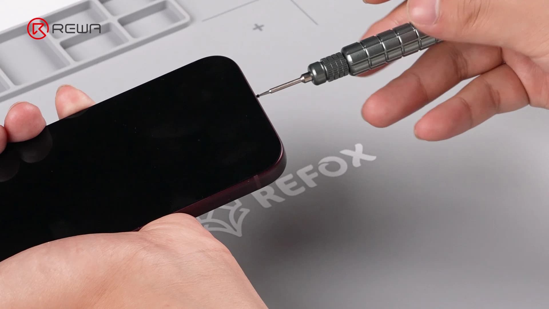 Removing the bottom screw of an iPhone using a precision Pentalobe screwdriver