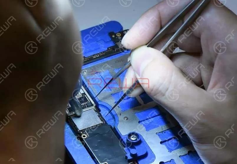 Jetzt können wir den NAND-Flash-Chip und ein neues WLAN-Modul auf die Platine löten. Tragen Sie etwas Flussmittelpaste auf das Lötpad auf. Bringen Sie den NAND-Flash-Chip in Position. Achten Sie darauf, ihn in der richtigen Richtung zu platzieren. Löten Sie ihn mit der Heißluftpistole QUICK 990AD an.