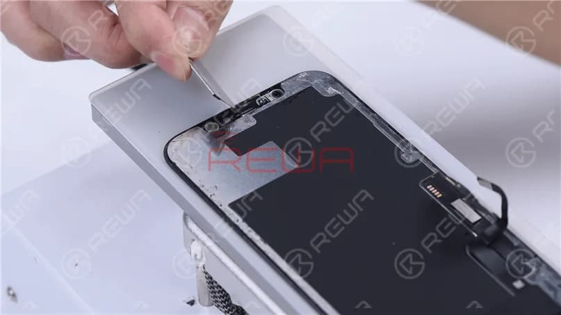 Remove excess adhesive on the ear speaker flex cable part.
