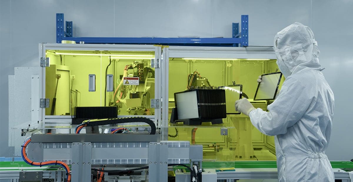 REWA technician operating quality-control testing equipment in a cleanroom